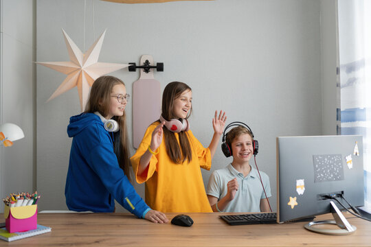 Happy friends enjoying computer game at home