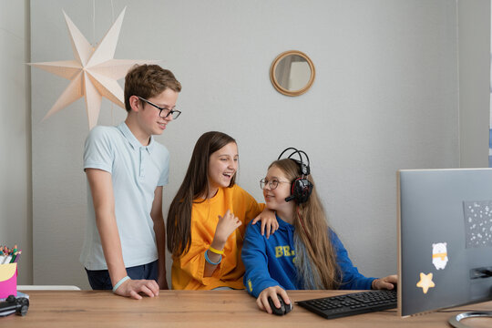 Friends talking with each other by computer on table at home