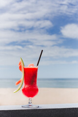 Fresh water melon shake on the beach with blue sky background.