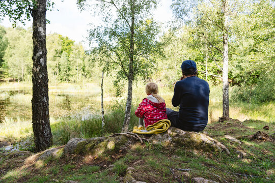 Father and daughter sitting together in forest