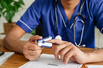 Male doctor checking pulse rate of himself in office