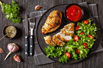 Baked Split Chicken Breasts with salad on plate