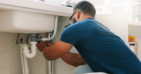 Plumber black man, kitchen and sink maintenance with tools, focus and pipe repair for drainage in...