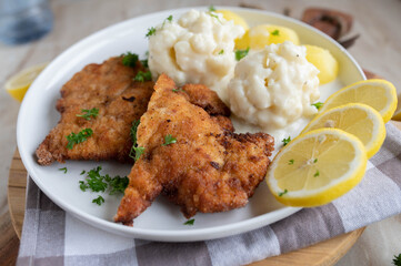 Vienna schnitzel with creamy cauliflower and boiled potatoes on a plate