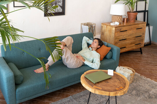 Smiling woman relaxing on sofa at home