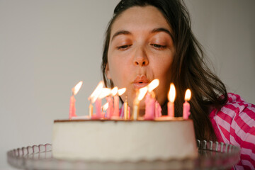 Woman blowing candles on birthday cake