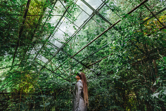 Woman watching trees through futuristic glasses in greenhouse