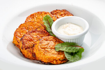 Pumpkin cutlets with white sauce. Vegetarian dish. Isolated image on a white background.