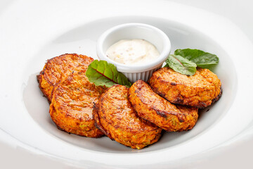 Pumpkin cutlets with white sauce. Vegetarian dish. Isolated image on a white background.