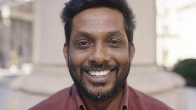Portrait of male looking to camera before smiling, in slow motion 
