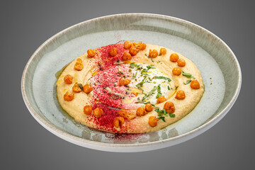 Chickpea hummus on decorative ceramic plate. Gray background.