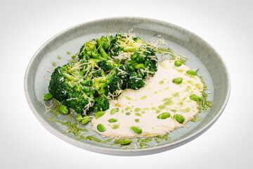 Steamed brocolli with cream sauce and parmesan. Isolated on a white background.