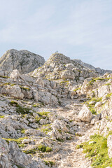 stone wall in the mountains, hikers walking