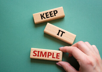 Keep it Simple symbol. Concept words Keep it Simple on wooden blocks. Businessman hand. Beautiful grey green background. Business and Keep it Simple concept. Copy space.