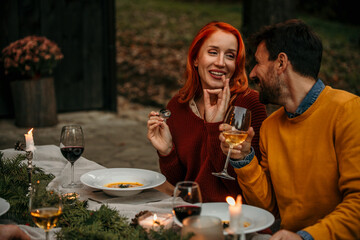 A smiling group of diners enjoying the outdoor meal, basking in the warm, sunlit garden atmosphere.