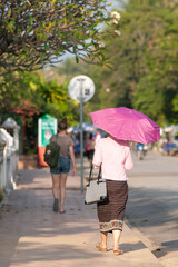 Laotian girl in traditional clothes walks on the street in Luang Prabang. - 644381162