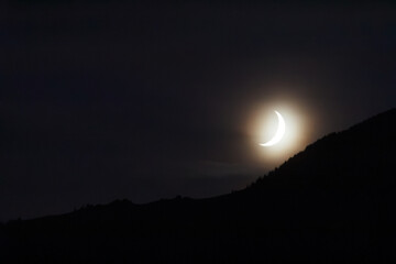 Croissant de lune décroissante, crescent moon over mountain at dusk