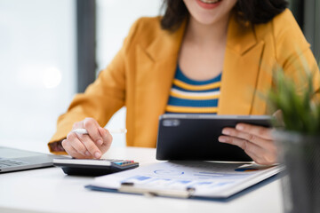 Business woman working on laptop and accounting financial report, accountant using calculator to calculate tax refund at office.