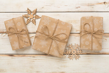 Craft christmas gift boxes on wooden background, top view