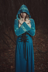 Fairy hooded woman in mystical forest - 644386386