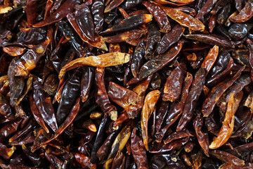 Red paprika peppers placed on a shelf for sale inside a market
