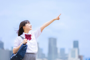 空を指さす高校生