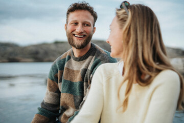 Happy young man enjoying with female friend near lake