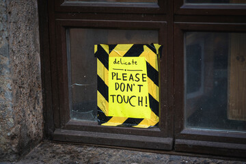 Delicate- please dont touch -sign on a broken window on a house