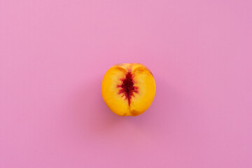 Peach on a pink background. Sliced peach on a pink background. Women's health theme.