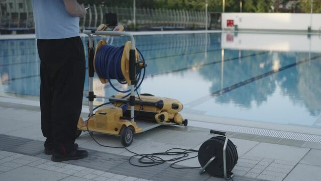 Man Standing in front of Automatic Pool Cleaner