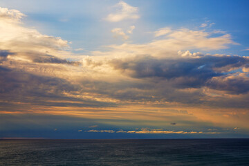 Landscape with the sunrise among the clouds at the sea.