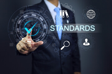 Businessman hand reach out to click check mark standards icon to applied require guide line in business or conforming work process. Compliance and assessment audit regulation on standard requirement