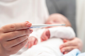 Checking infant temperature in loving arms, Concept of health precautions for newborns