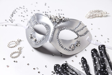 Carnival mask and jewelry on white background, close up