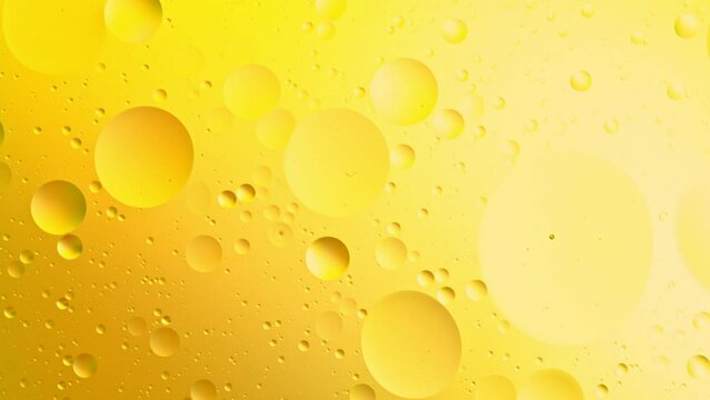 Slow Motion of Flowing Golden Oil Bubbles in Water. Abstract Colored Background. Filmed on High Speed Cinema Camera.