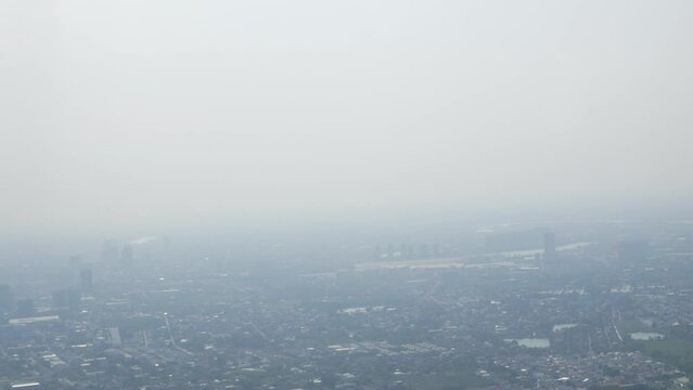 Aerial view of Environmental issue of air pollution pm 2.5 over sky of Bangkok metropolis from flying areoplane aircraft's window.
