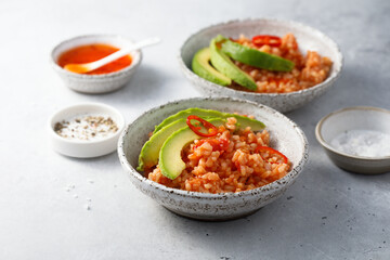 Spicy rice with avocado and chili sauce