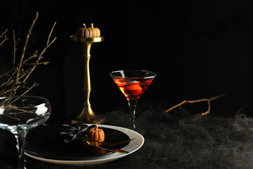 Festive table set for Halloween dinner with candles and cutlery