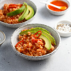 Spicy rice with avocado and chili sauce