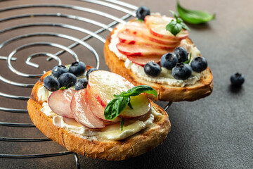 Summer Bruschetta With cream cheese, honey, peaches and blueberries, Food recipe background. Close up