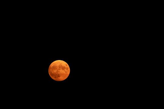 Red or Blood Moon in South of France on March 30th, 2023, with copy space in the dark sky