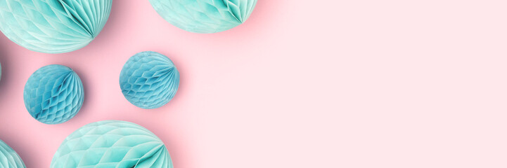 Banner with blue tissue paper balls different sizes scattered on a pink background. Creative composition.