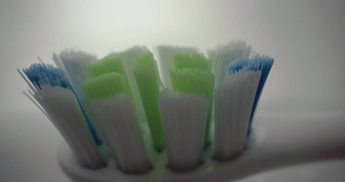 Close-up of a toothbrush with bristles in the bathroom. Daily hygiene procedures at home. High quality 4k footage