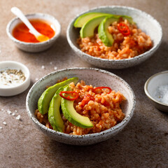 Spicy rice with avocado and chili sauce