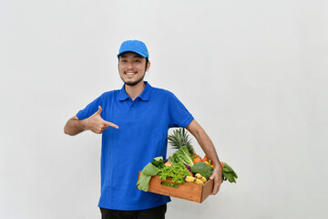 Delivery guy holding a bag of groceries isolated on white background.