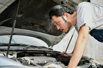 Asian people are repairing cars on the roadside. Auto mechanic checking car engine.