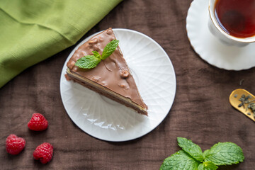 chocolate cake on white plate and tea with strawberry