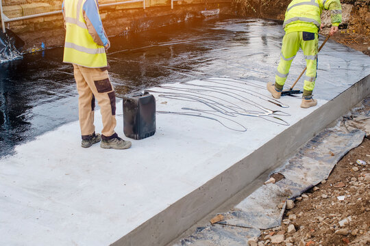 Waterproofing coating. Builder applying waterproofing bitumen mastic on concrete