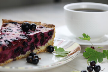 Baked pie with season berries and cup of coffee on wooden background