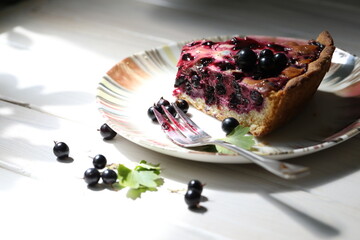 Baked pie with season berries and cup of coffee on wooden background